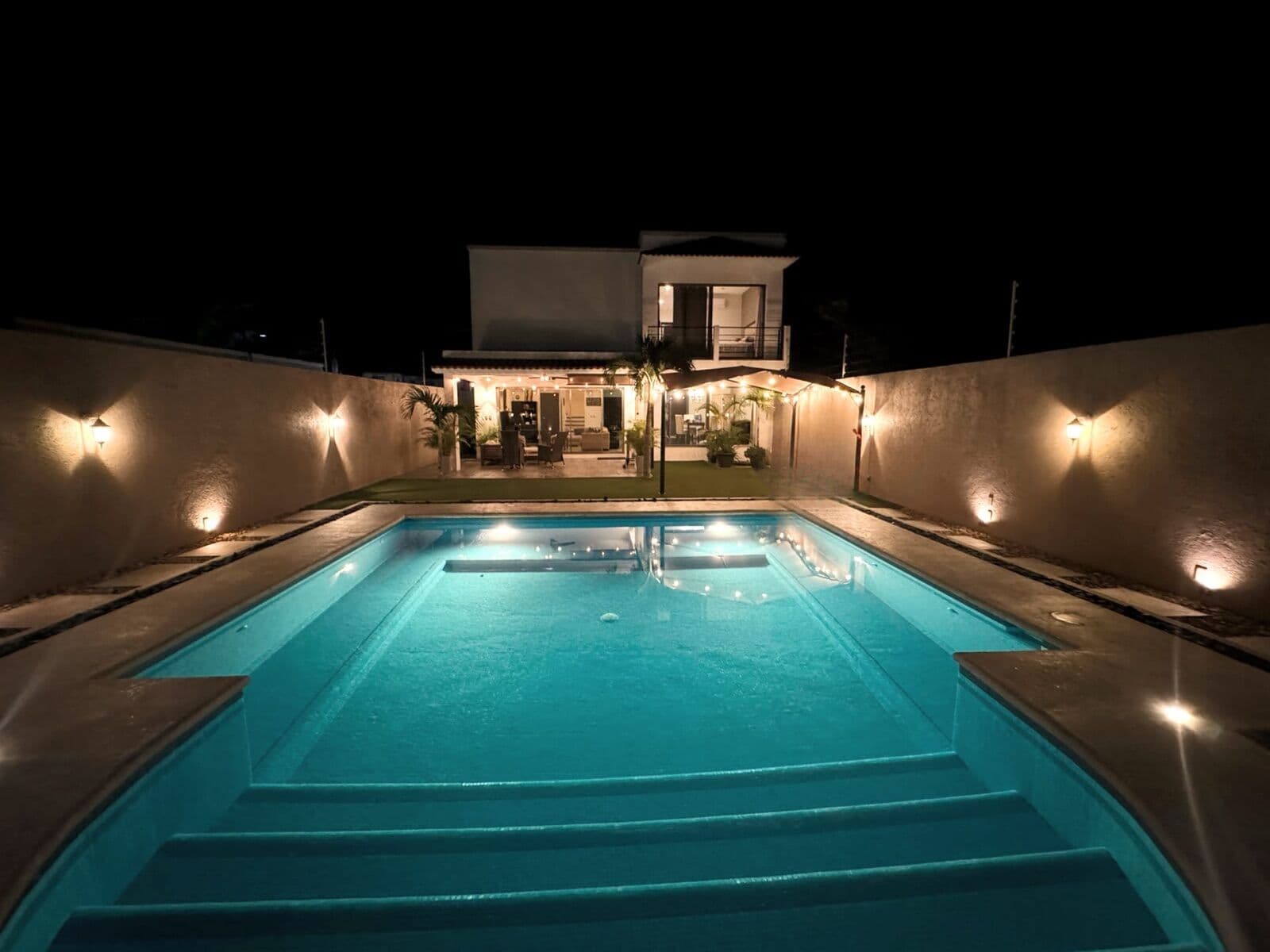 Illuminated pool and terrace at night